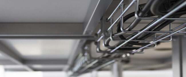 Metal cable tray mounted under the desk in the office